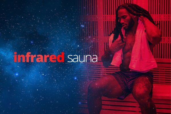 A man with dreadlocks sits shirtless in a red-lit sauna